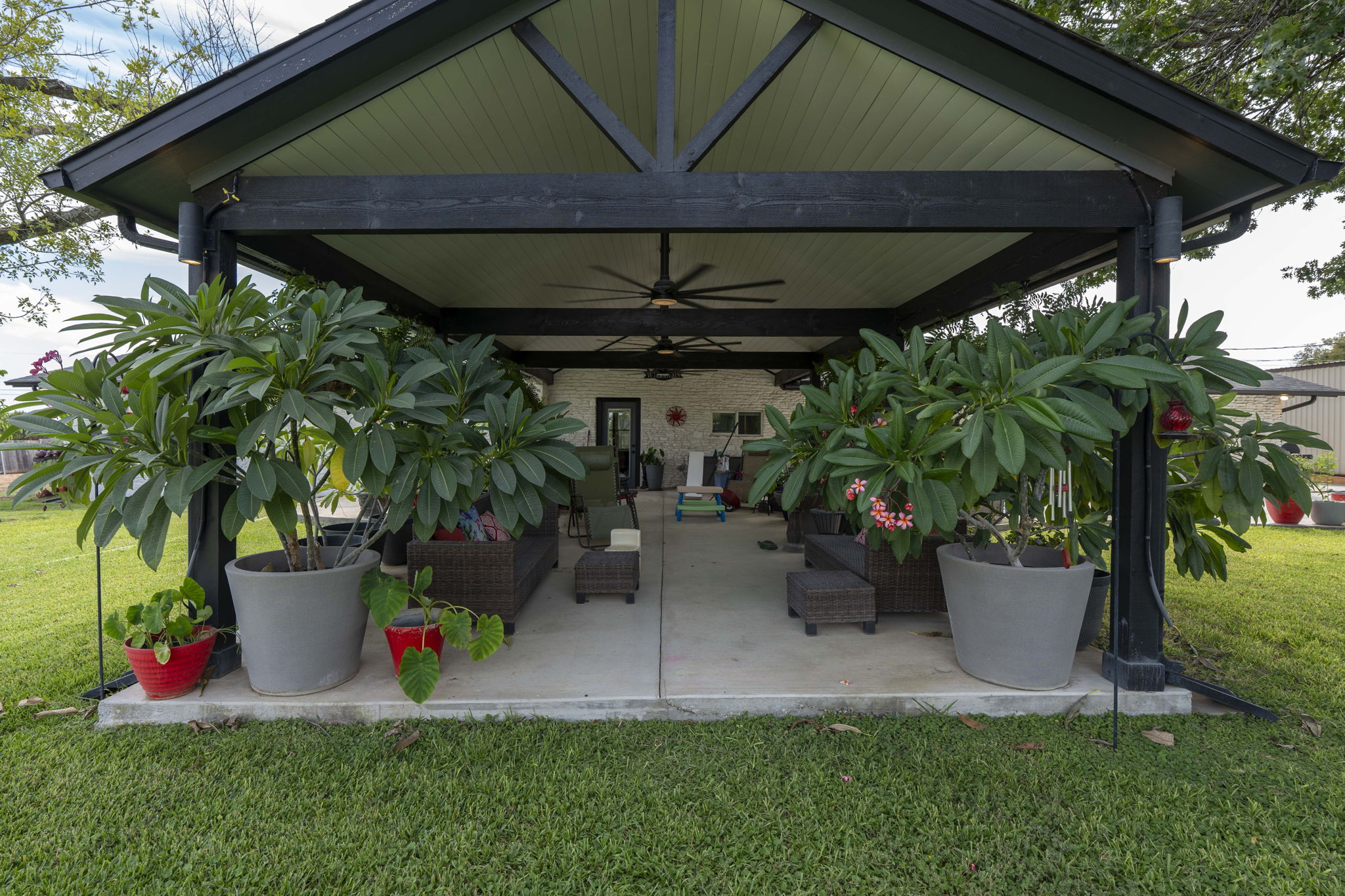 130 Hy Road Buda, TX 78610 - Photo 23 of 32 Back of house featuring a ceiling fan, a yard, a patio area, and an outdoor hangout area