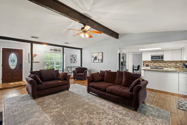 a living room with furniture and kitchen view
