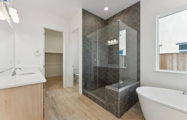 a bathroom with a sink a toilet a mirror and shower