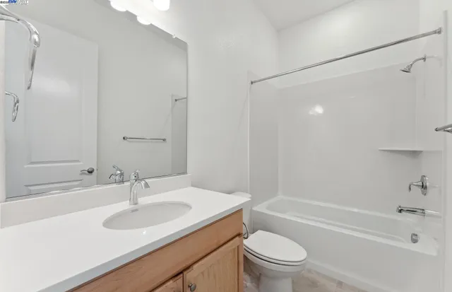 a bathroom with a granite countertop sink a toilet and shower