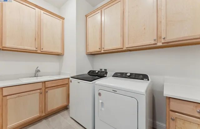 a utility room with sink dryer and washer