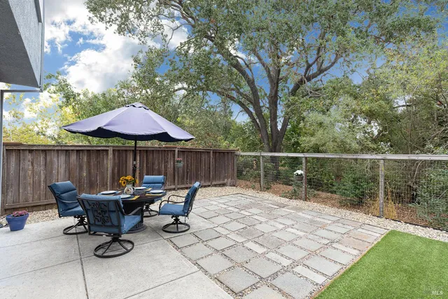 a view of a backyard with chairs and wooden fence