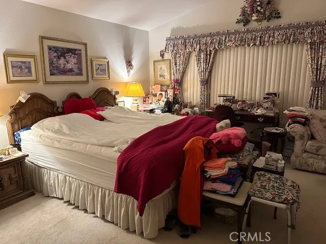 a bedroom with a bed and dresser next to a window