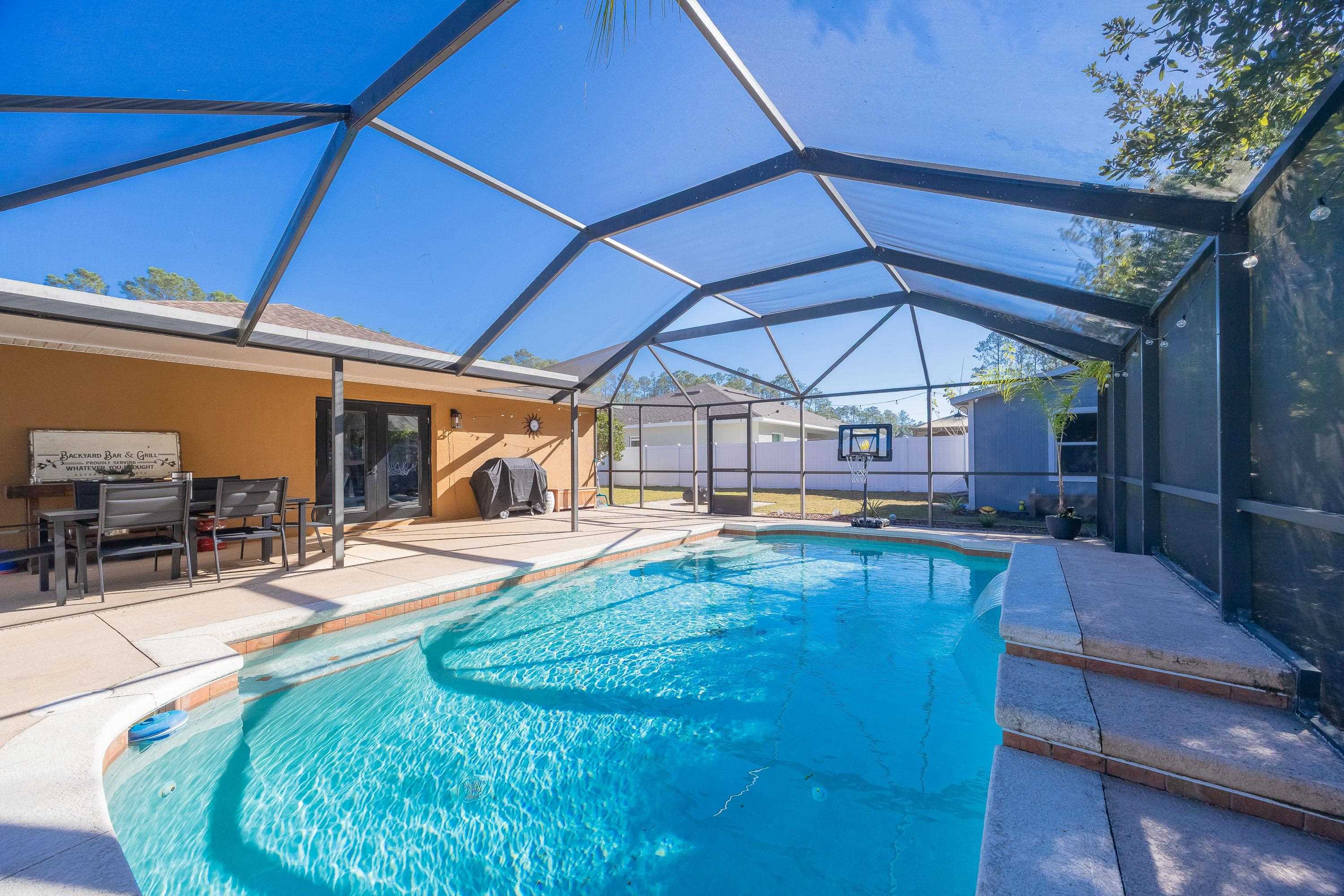 5 Rippling Place Palm Coast, FL 32164 - Photo 2 of 50 View of swimming pool featuring a sunroom, a lanai, a patio area, and grilling area