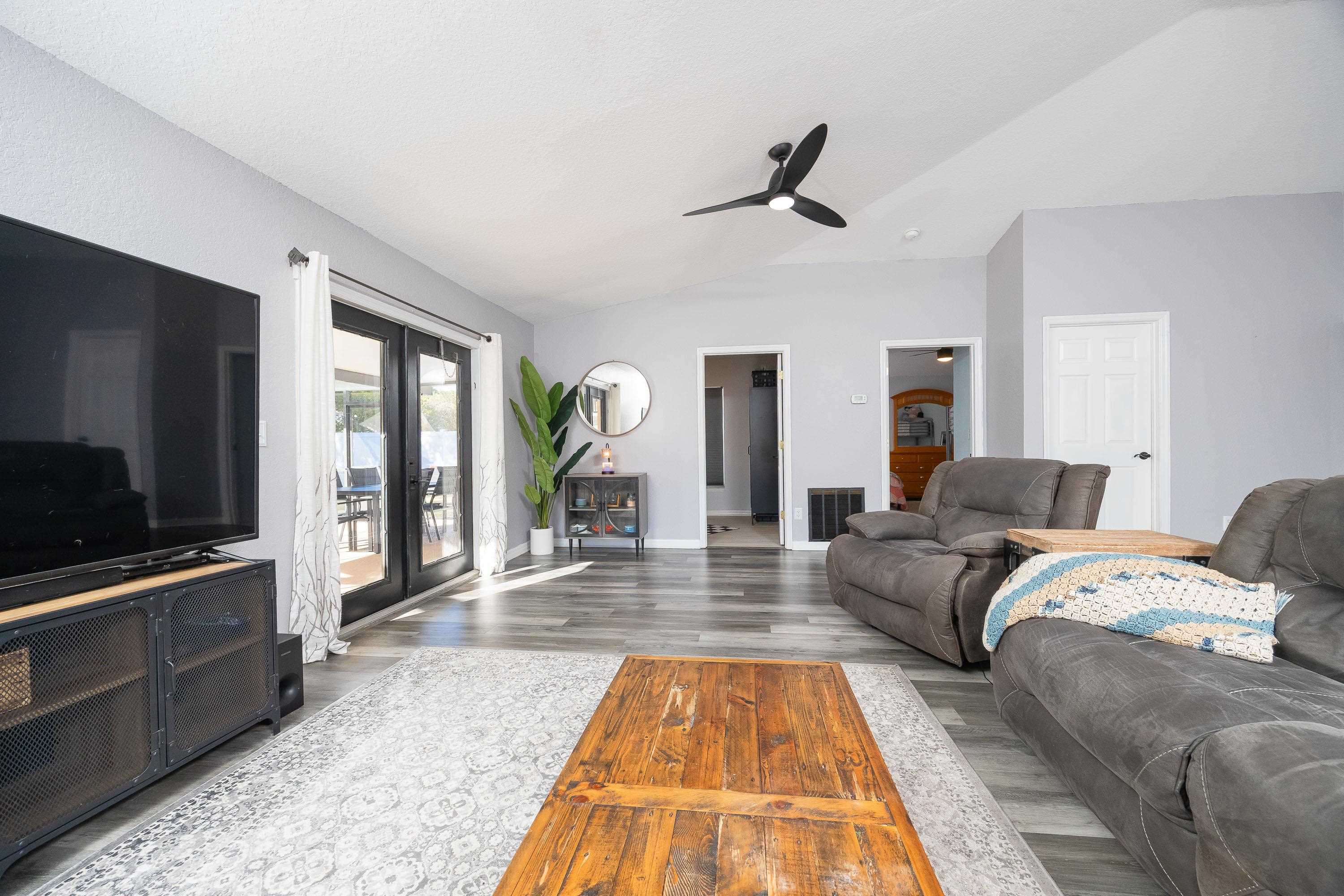 5 Rippling Place Palm Coast, FL 32164 - Photo 24 of 50 Living room with lofted ceiling, wood finished floors, and a ceiling fan
