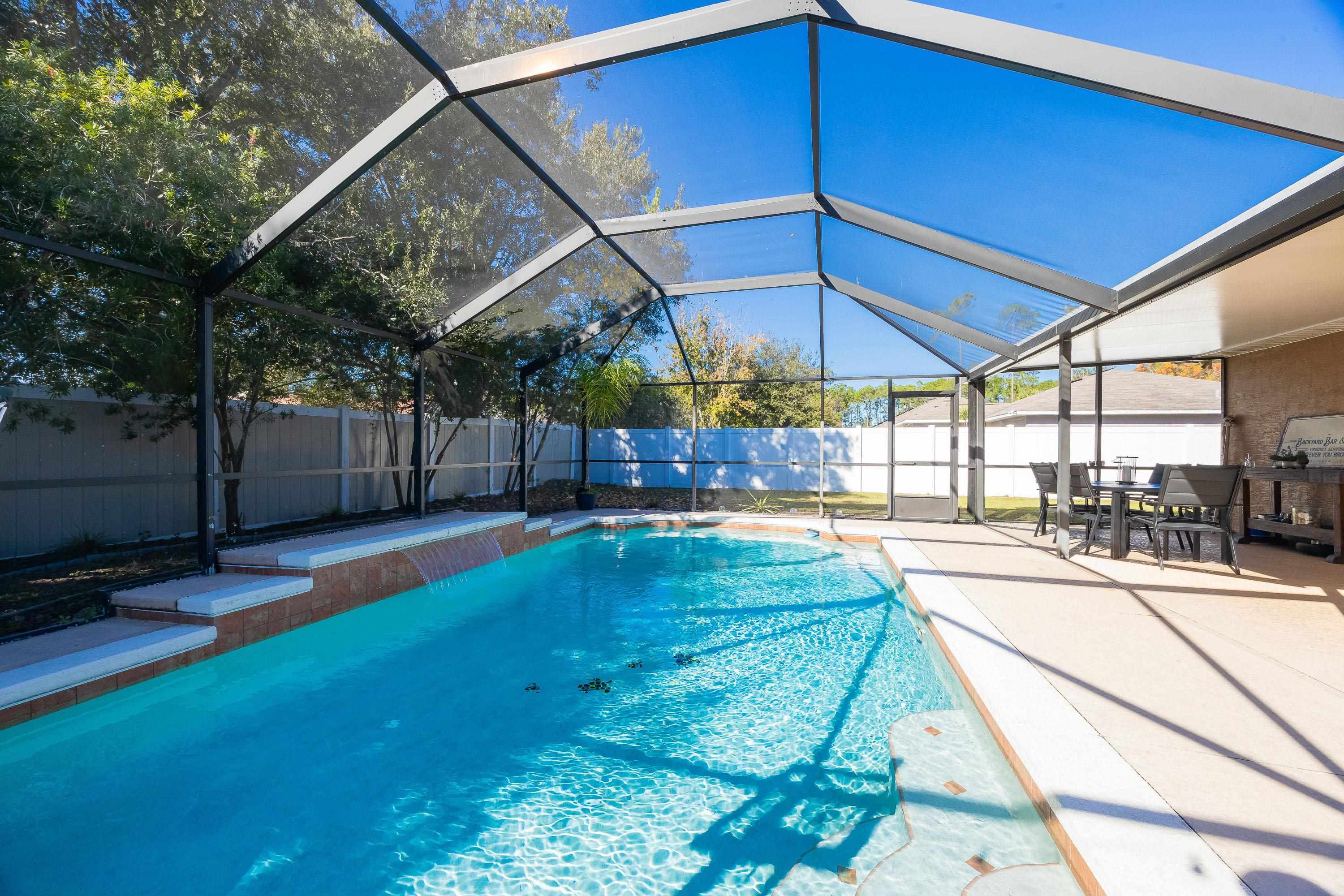5 Rippling Place Palm Coast, FL 32164 - Photo 29 of 50 View of swimming pool featuring glass enclosure, a sunroom, and a fenced backyard