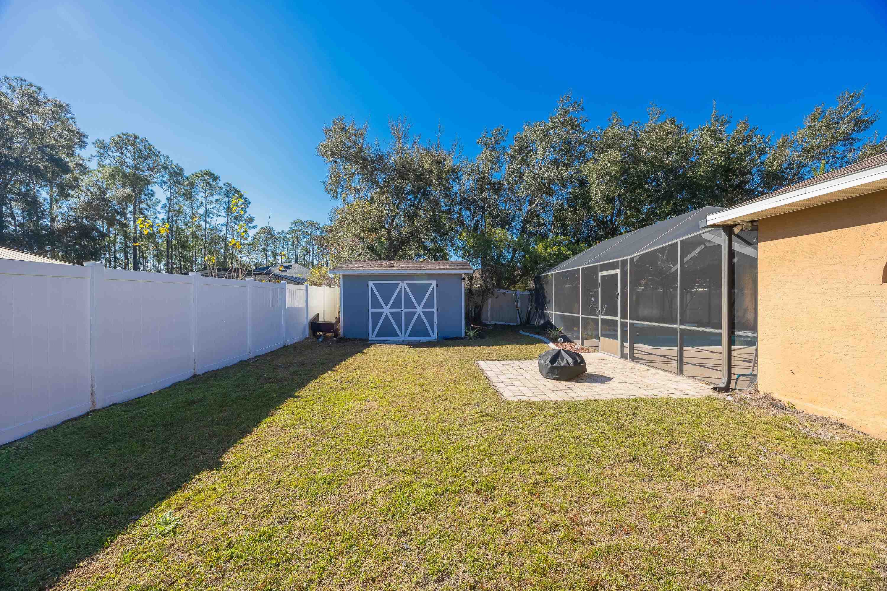 5 Rippling Place Palm Coast, FL 32164 - Photo 33 of 50 Fenced backyard featuring a shed, glass enclosure, a sunroom, and a patio