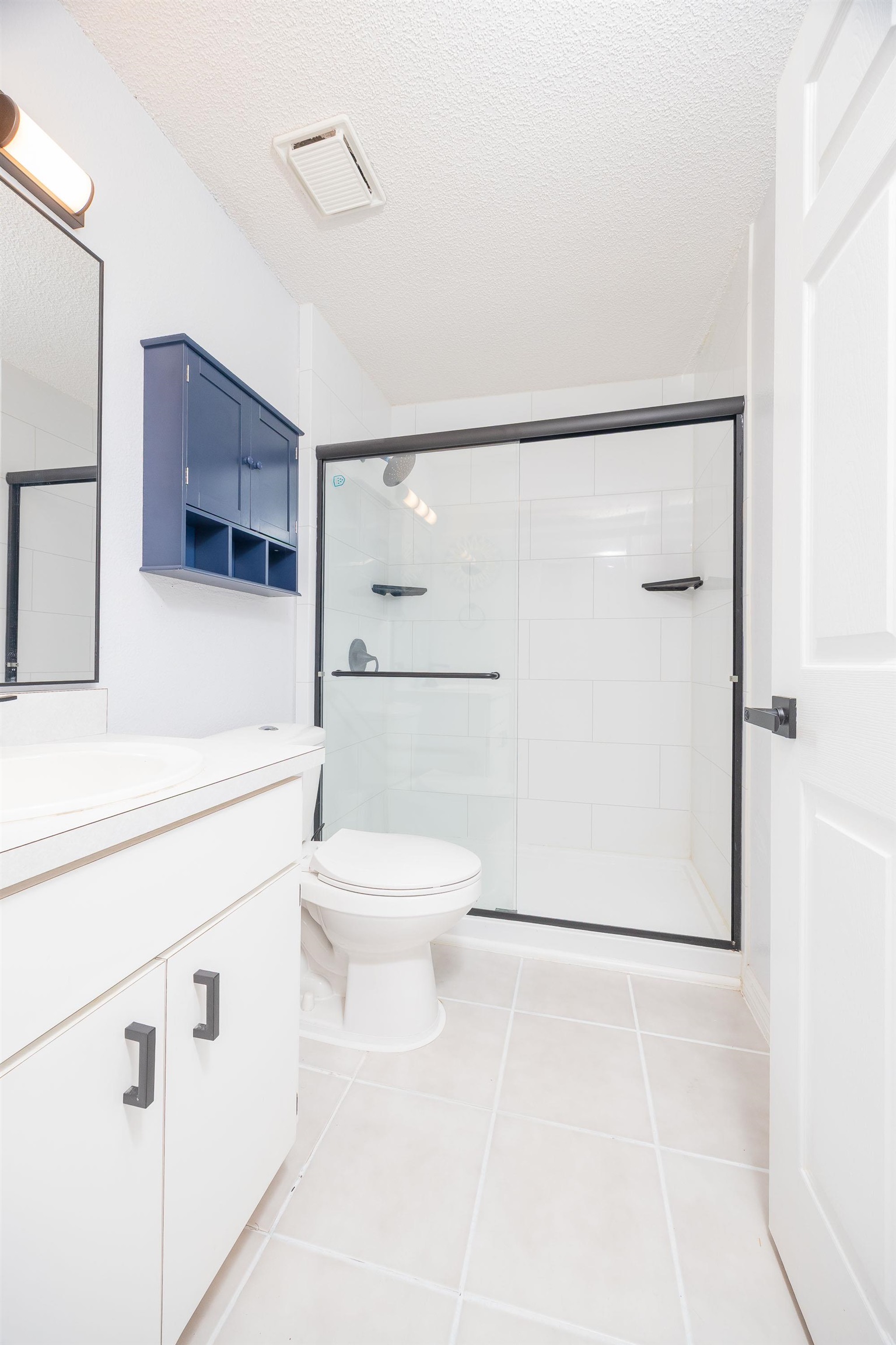 5 Rippling Place Palm Coast, FL 32164 - Photo 40 of 50 Bathroom featuring light tile patterned floors, vanity, a textured ceiling, and a stall shower