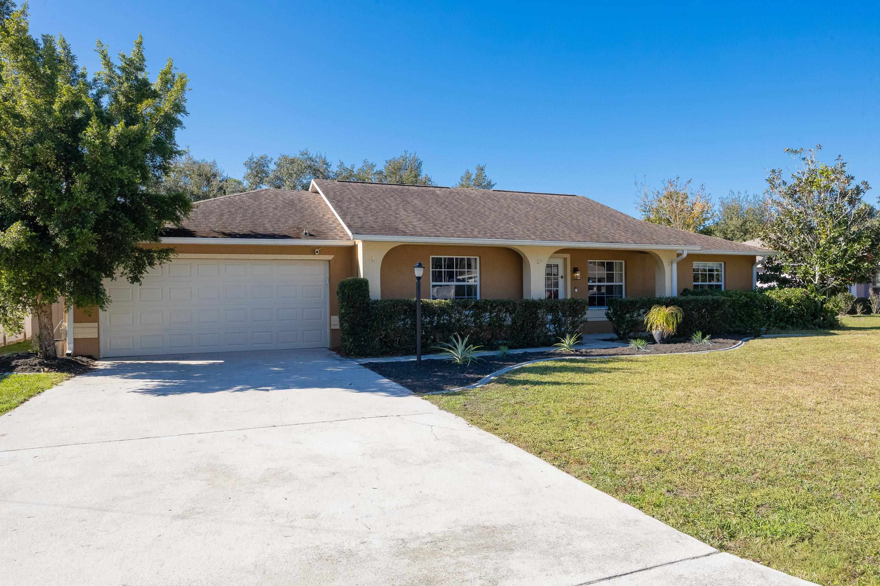 5 Rippling Place Palm Coast, FL 32164 - Photo 5 of 50 Single story home with concrete driveway, stucco siding, a front lawn, an attached garage, and a porch