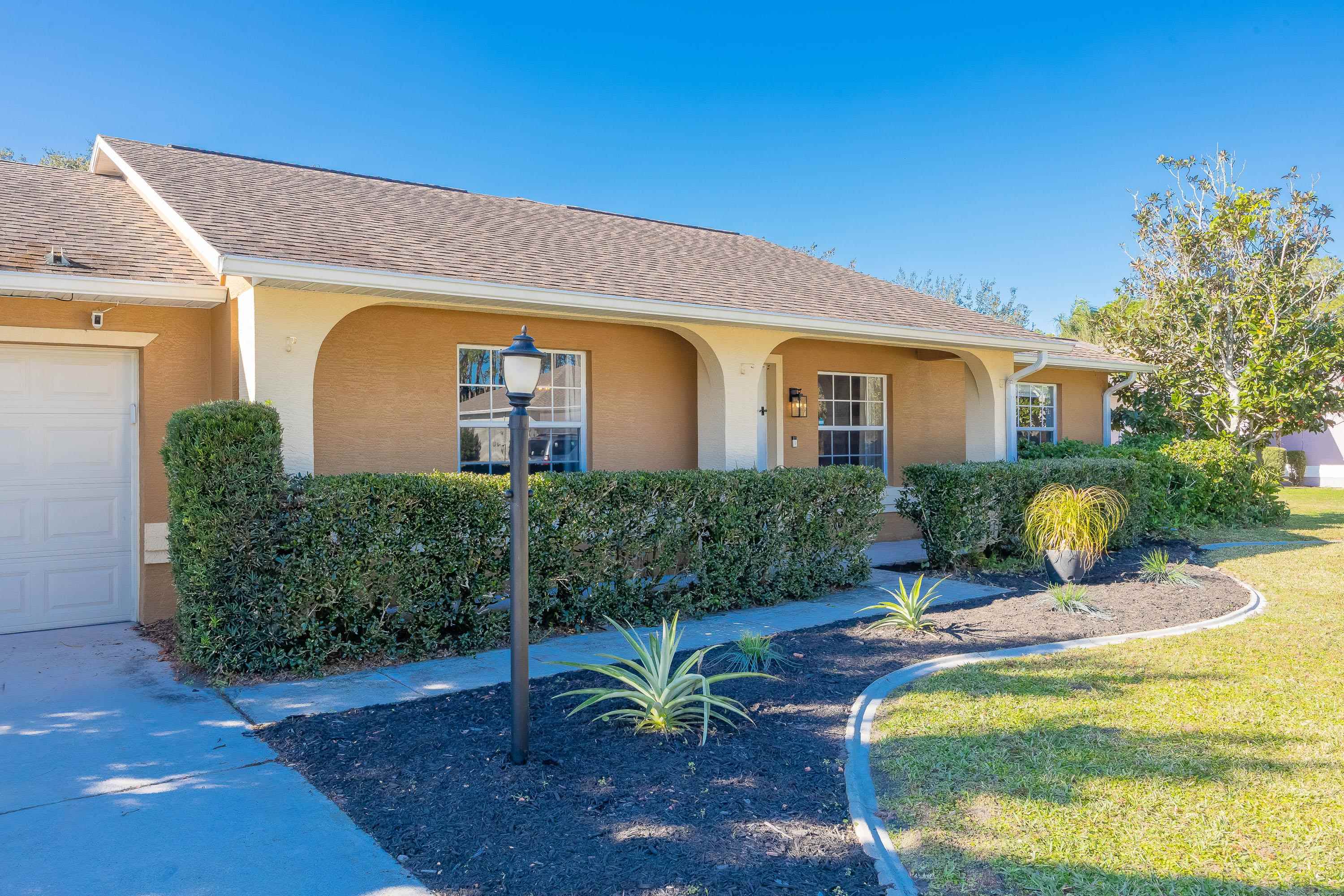 5 Rippling Place Palm Coast, FL 32164 - Photo 6 of 50 View of front of house with stucco siding, roof with shingles, a front lawn, and a garage