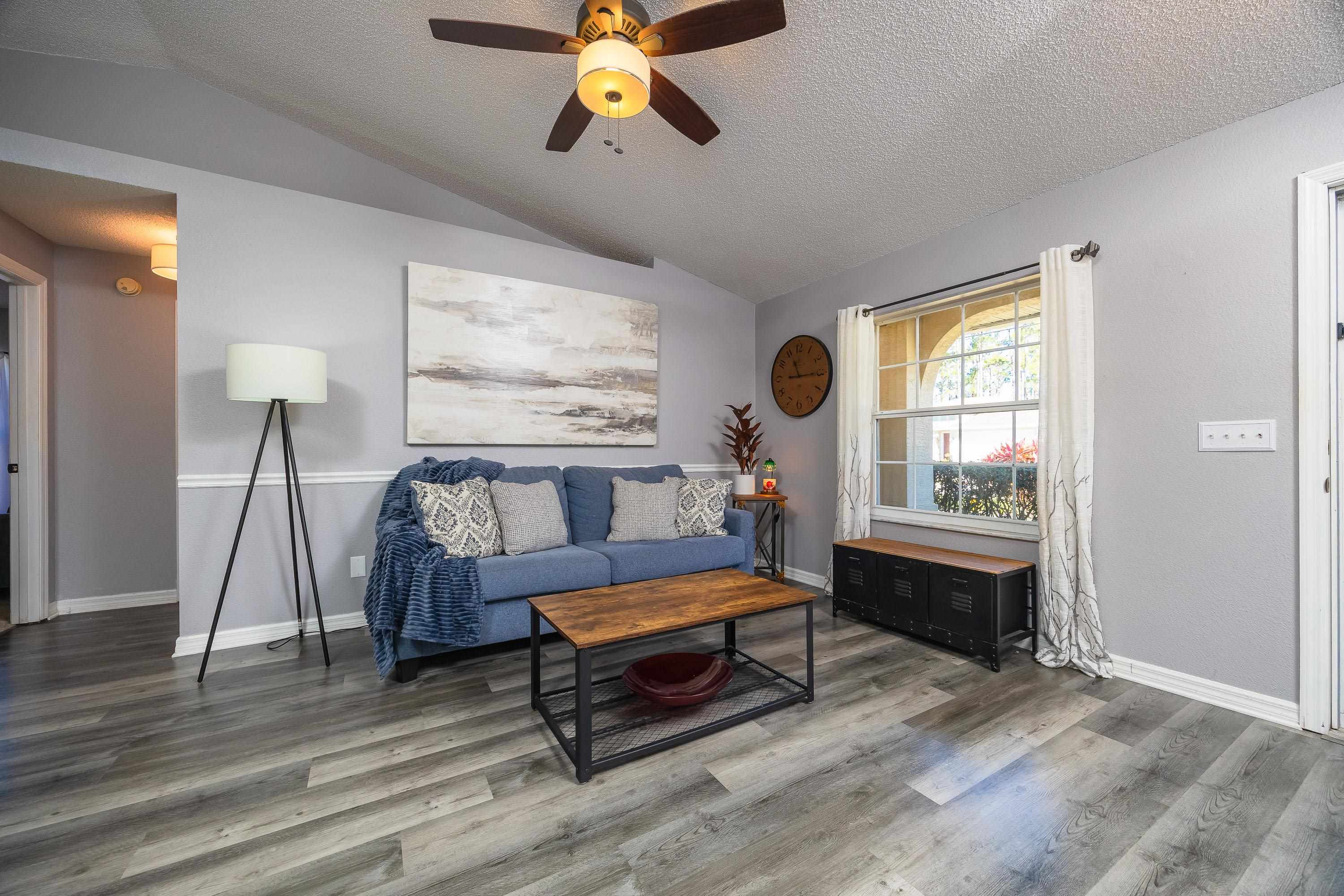 5 Rippling Place Palm Coast, FL 32164 - Photo 9 of 50 Living area featuring vaulted ceiling, a textured ceiling, ceiling fan, and wood finished floors