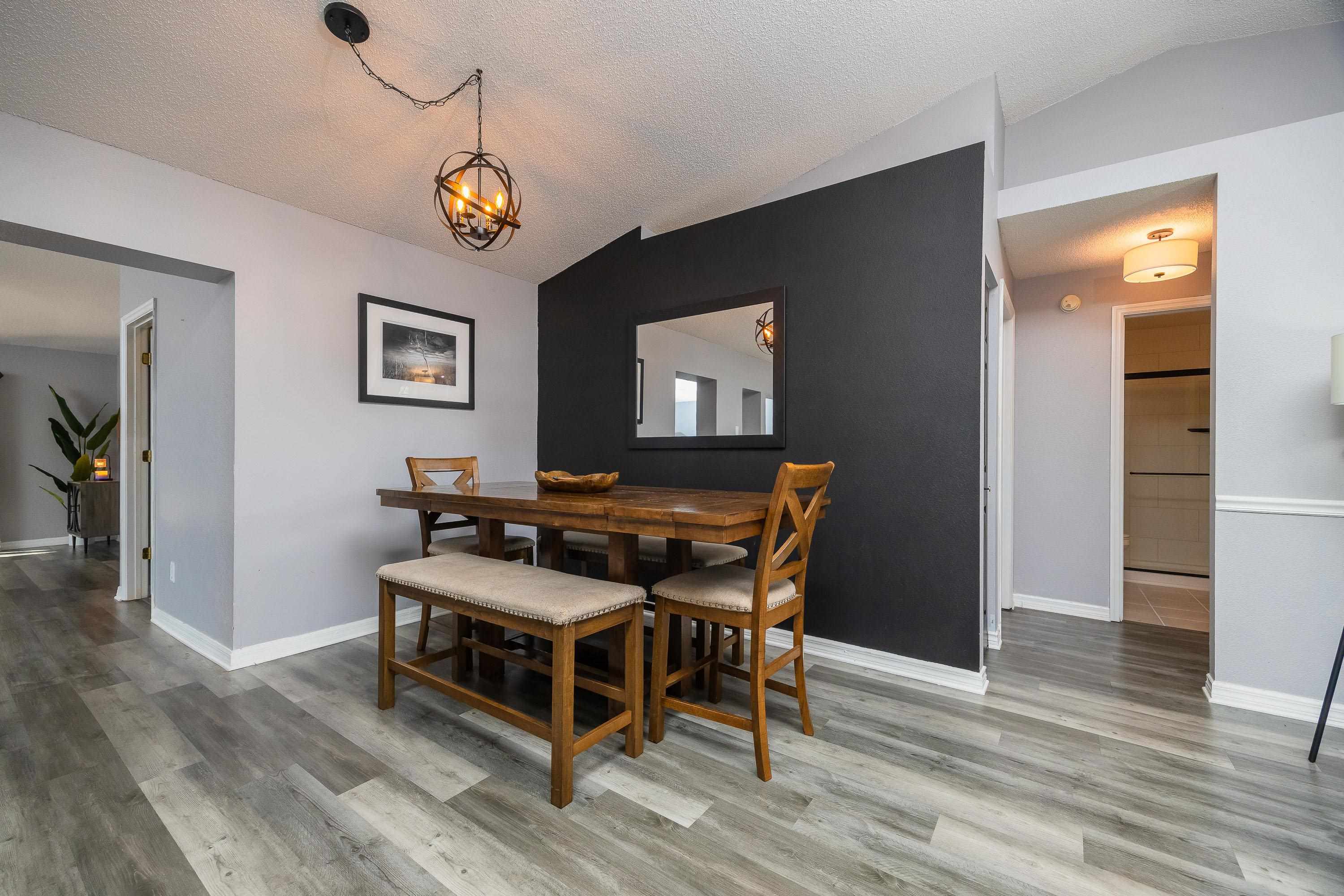 5 Rippling Place Palm Coast, FL 32164 - Photo 10 of 50 Dining room featuring vaulted ceiling, a textured ceiling, light wood-type flooring, and a chandelier