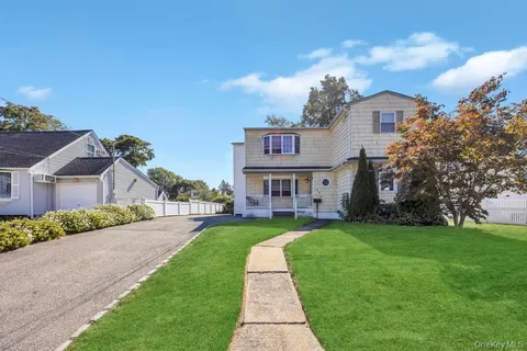 a view of a big house with a big yard and large trees