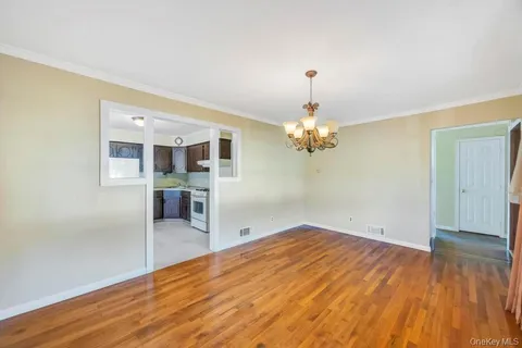 a view of a livingroom with wooden floor and a ceiling fan