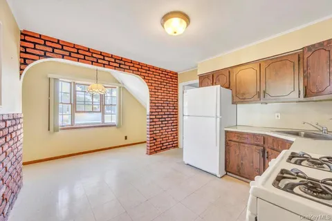 a view of a kitchen with fridge and workspace