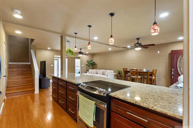 a kitchen with a stove a refrigerator and a wooden floor