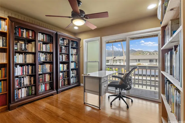 a view of a livingroom with furniture bookshelf and a floor to ceiling window