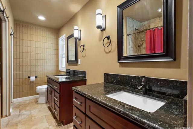 a bathroom with a granite countertop sink a mirror a vanity and a shower