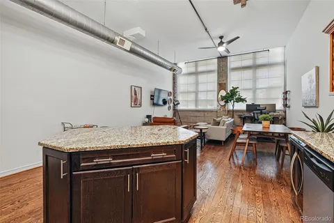 a open kitchen with stainless steel appliances granite countertop a stove and a wooden floors
