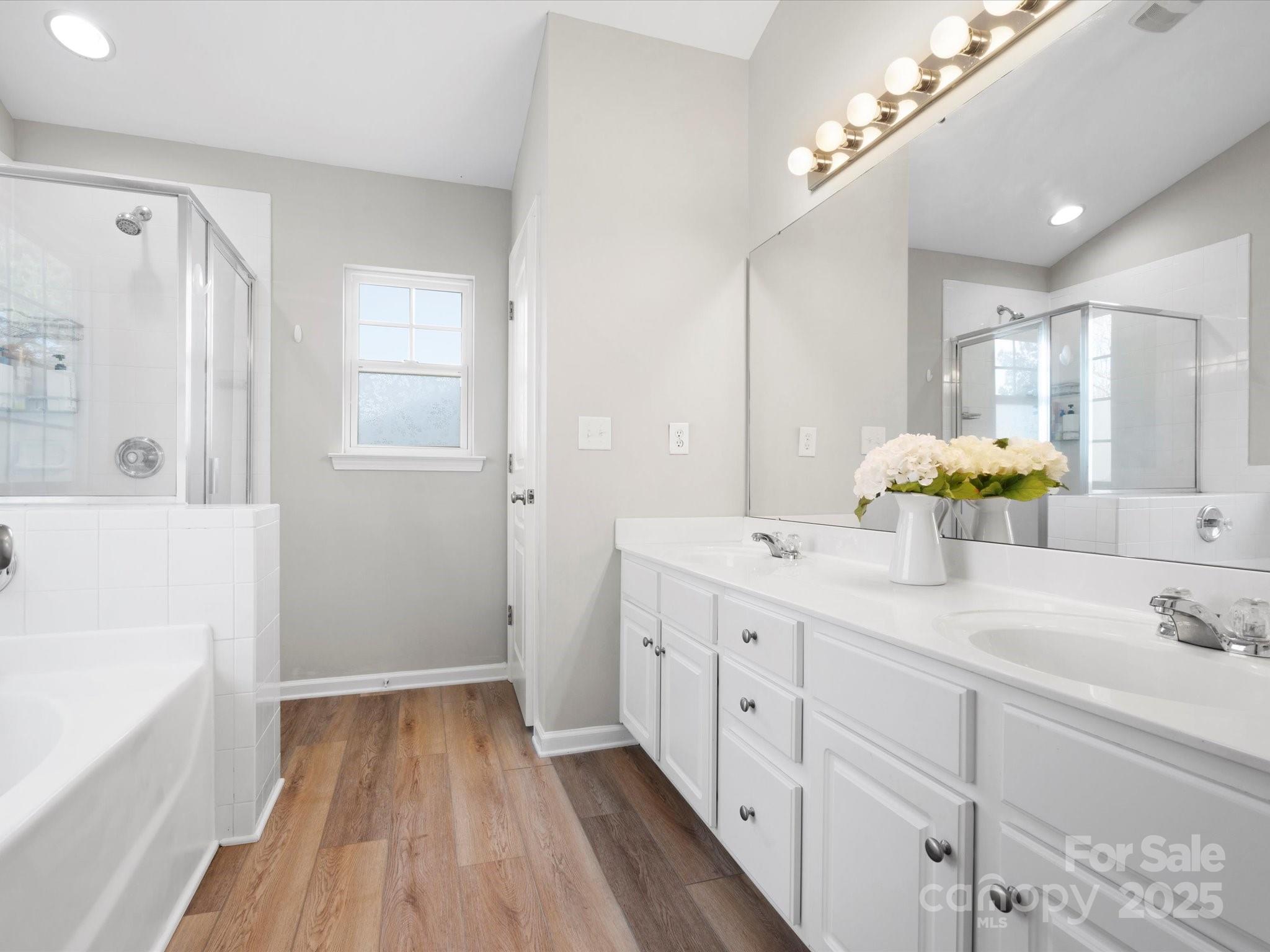 421 Silver Cypress Lane Fort Mill, SC 29708 - Photo 25 of 37 a spacious bathroom with a double vanity sink a mirror a shower and a bathtub