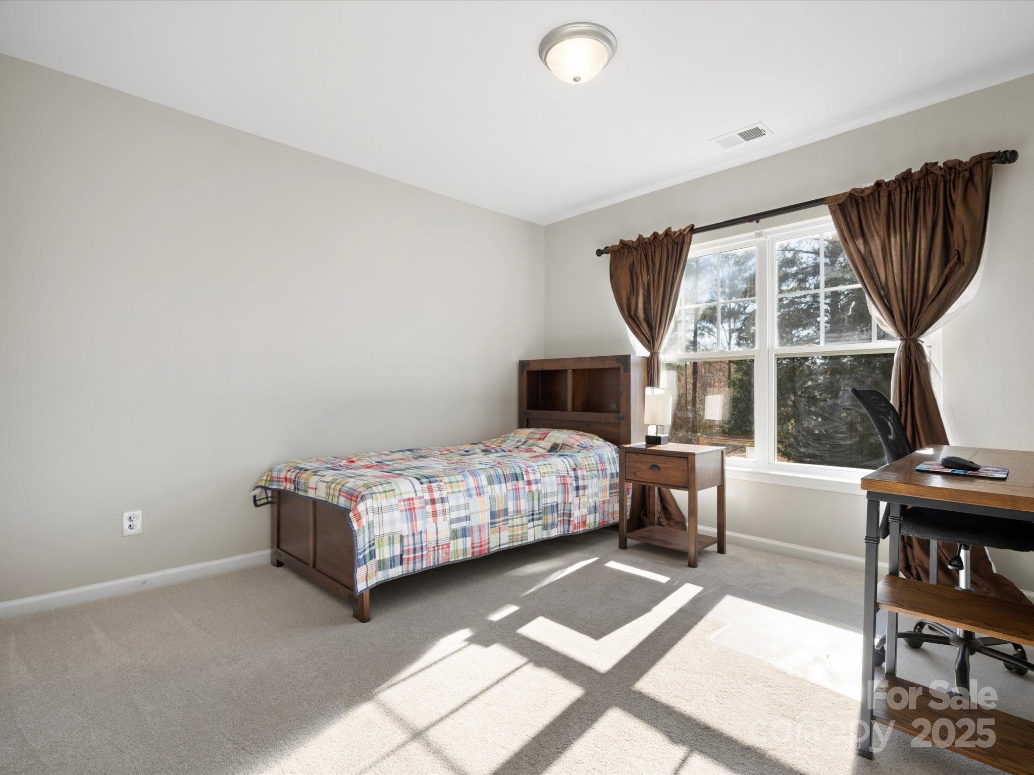421 Silver Cypress Lane Fort Mill, SC 29708 - Photo 29 of 37 a bedroom with a bed wooden floor and a large window