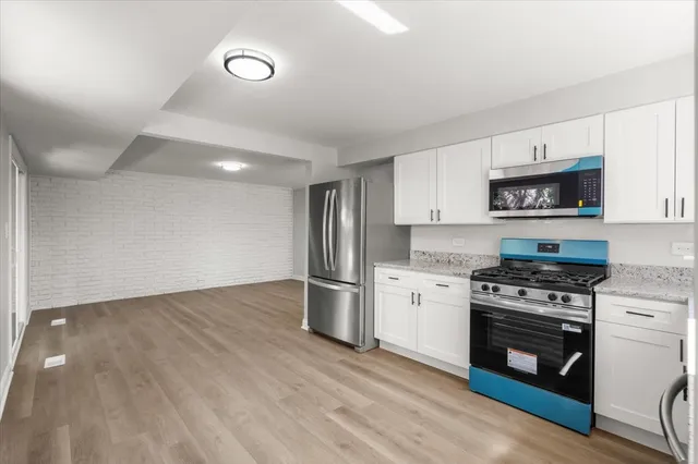 a kitchen with a stove a refrigerator and a microwave