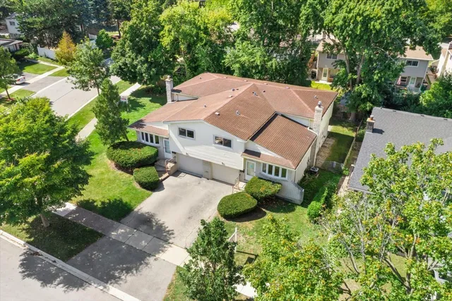 an aerial view of a house with a yard and large trees