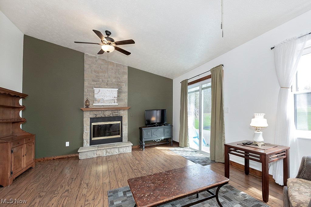6881 Lake Road Medina, OH 44256 - Photo 5 of 34 Living area with a fireplace, a textured ceiling, a ceiling fan, wood finished floors, and lofted ceiling