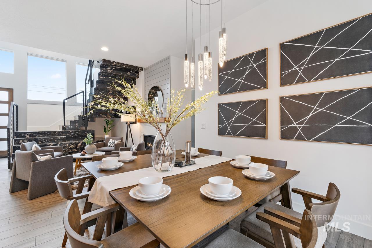 599 West Warren Street Boise, ID 83706 - Photo 10 of 41 Open-concept dining area featuring wood-finish flooring, a contemporary chandelier, and a solid wood dining table