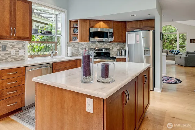 a kitchen with stainless steel appliances granite countertop a sink a stove and a refrigerator