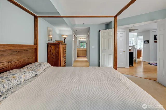 a bedroom with a bed and closet with wooden floor