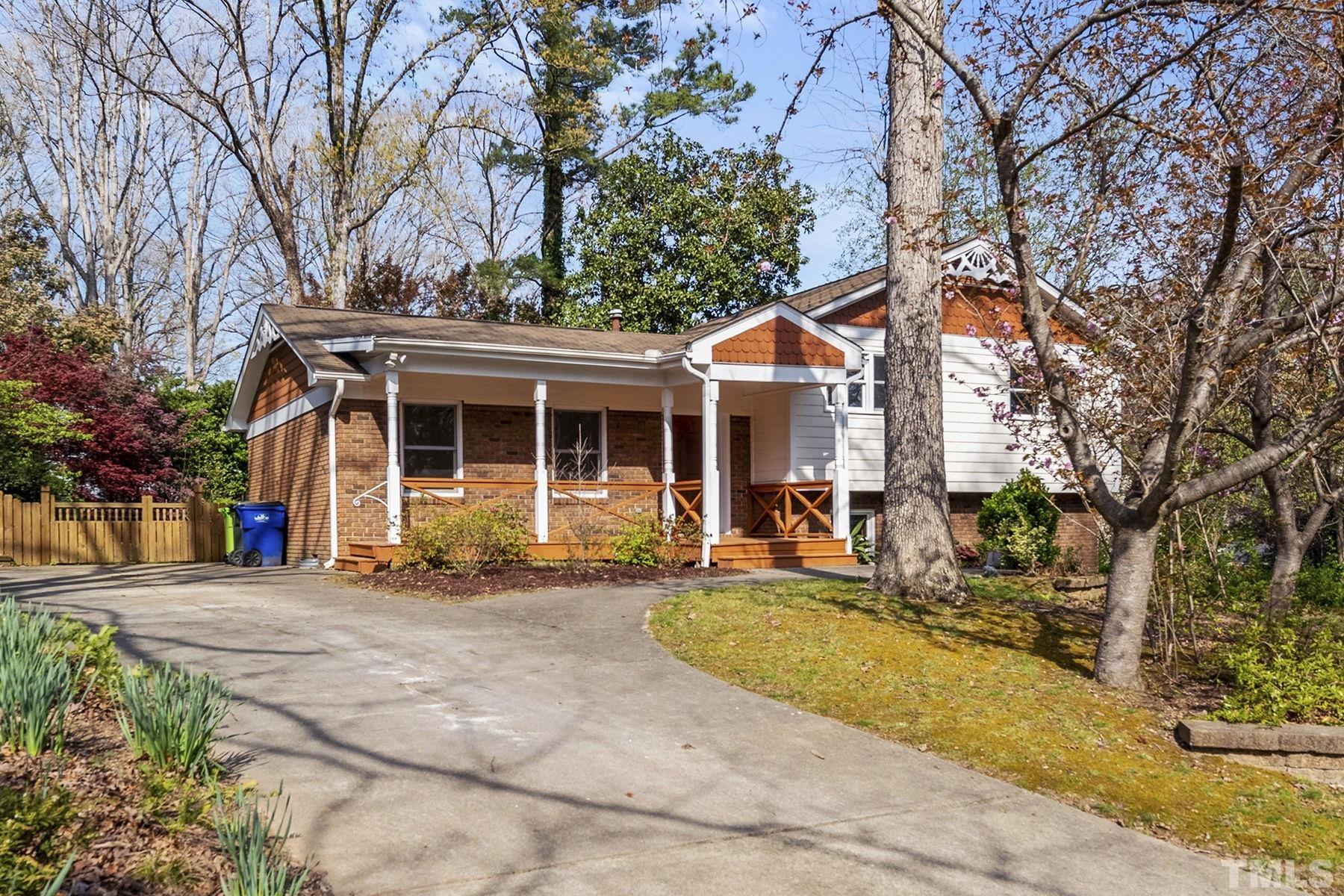 a front view of a house with a garden and trees