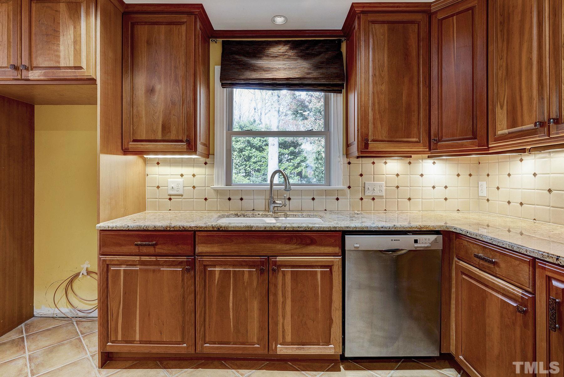 5505 Knollwood Road Raleigh, NC 27609 - Photo 10 of 33 a kitchen with stainless steel appliances granite countertop wooden cabinets a sink and a counter space