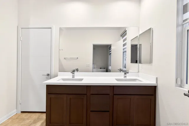 a bathroom with a double vanity sink and a mirror