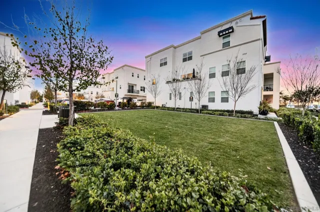 a view of a white house with a big yard and large trees