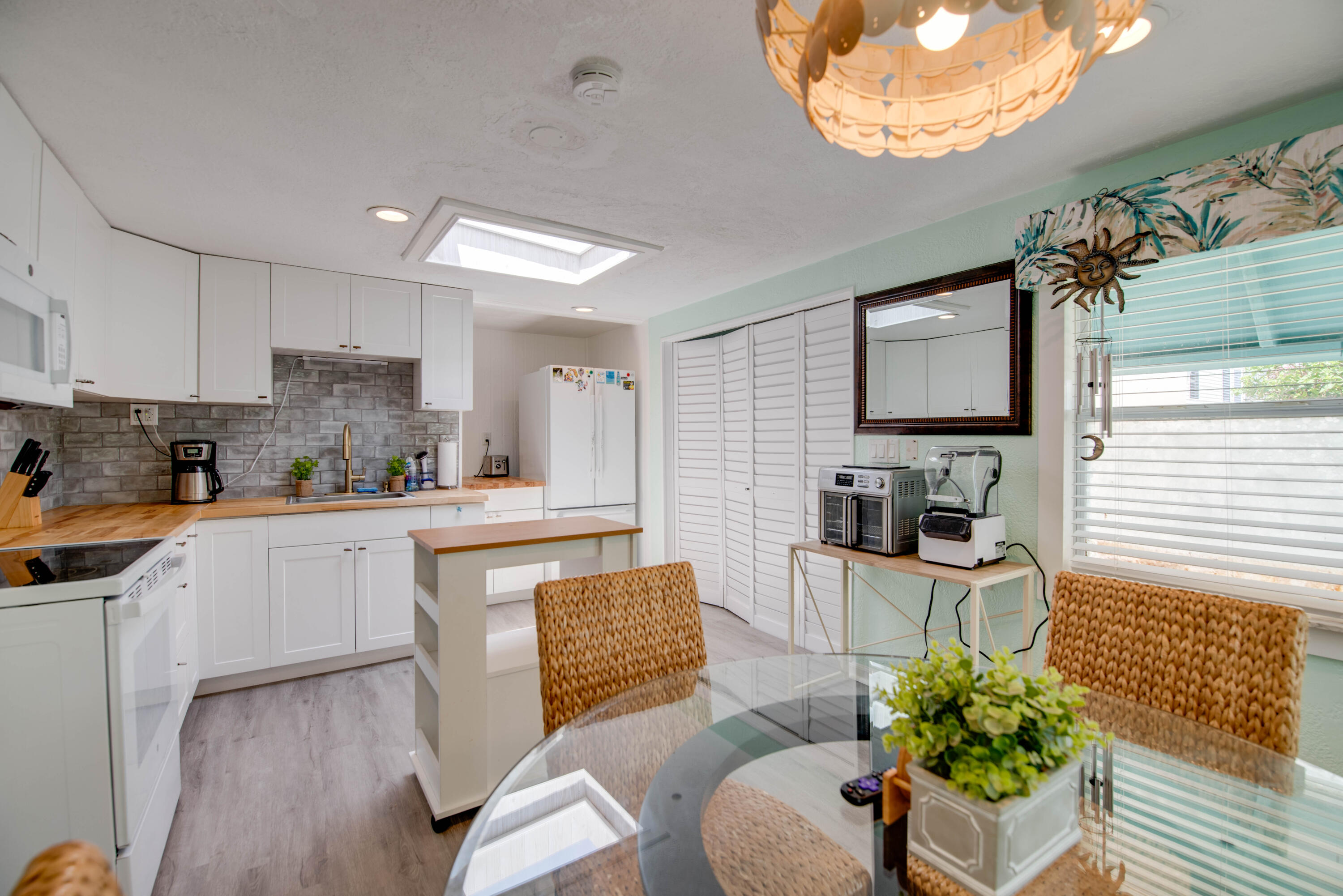 31541 Ave A Big Pine Key, FL 33043 - Photo 2 of 35 a kitchen with stainless steel appliances granite countertop a stove top oven a sink dishwasher and white cabinets with wooden floor