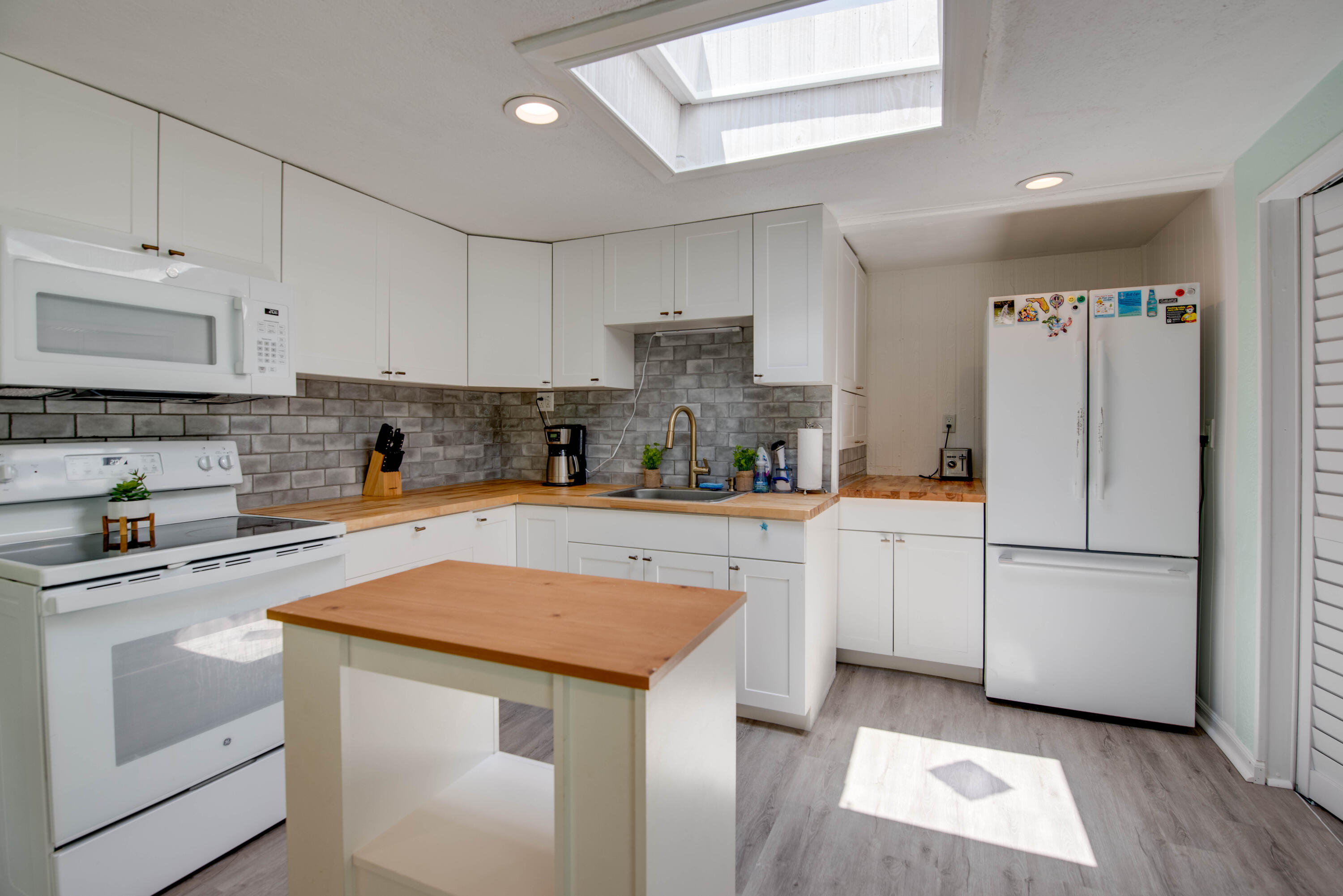 31541 Ave A Big Pine Key, FL 33043 - Photo 3 of 35 a kitchen with white cabinets and white appliances