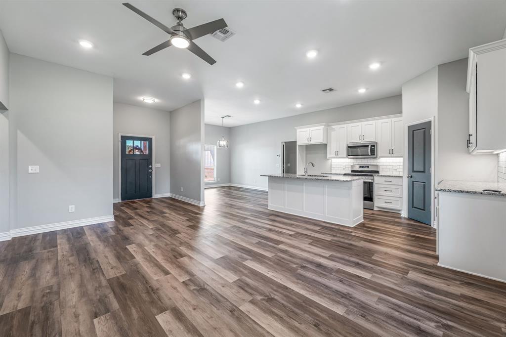 1501 Johnson Road, Unit A Iowa Park, TX 76367 - Photo 9 of 30 a view of kitchen with kitchen island wooden floors appliances and cabinets