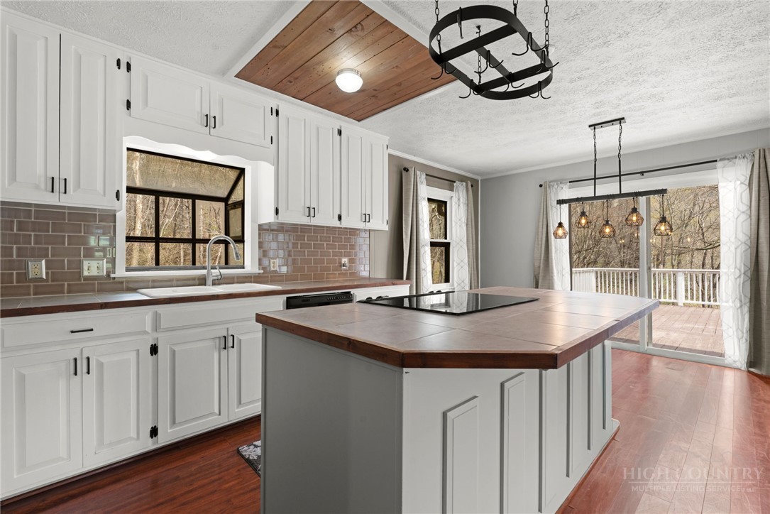 2345 Watauga River Road Sugar Grove, NC 28679 - Photo 11 of 50 a kitchen with stainless steel appliances granite countertop a stove a sink dishwasher and white cabinets with wooden floor