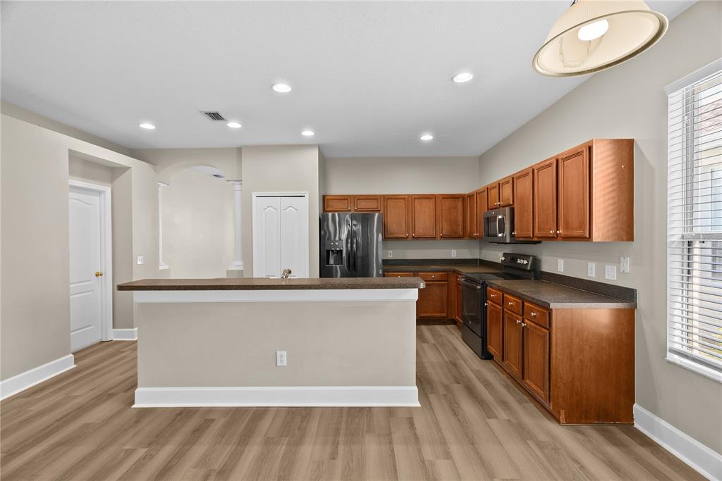 5012 Mirror Ridge Court Lutz, FL 33558 - Photo 11 of 44 a kitchen with stainless steel appliances granite countertop a stove a sink and a refrigerator