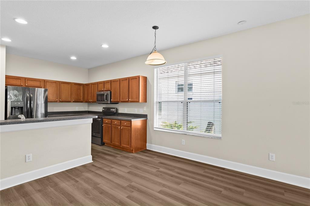 5012 Mirror Ridge Court Lutz, FL 33558 - Photo 12 of 44 a kitchen with stainless steel appliances granite countertop a stove a sink dishwasher and a refrigerator with wooden floor