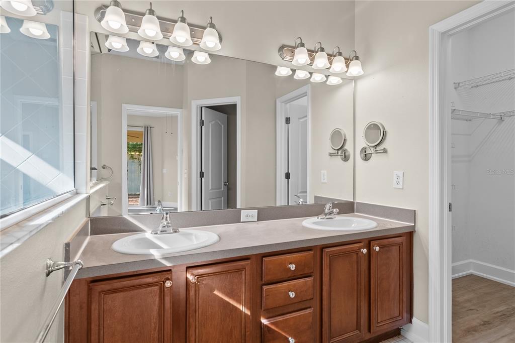 5012 Mirror Ridge Court Lutz, FL 33558 - Photo 23 of 44 a bathroom with a granite countertop sink a large mirror and a shower