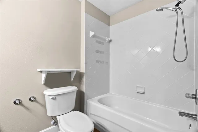 a white toilet sitting next to a bath tub