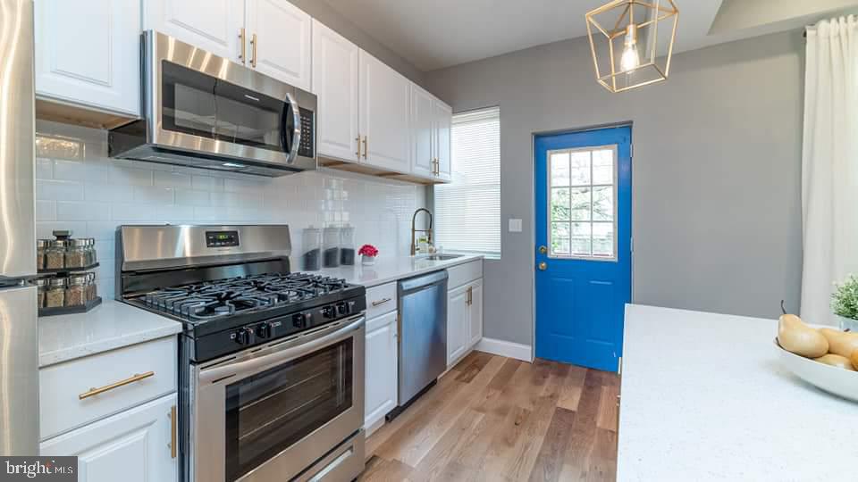 310 Marydell Road Baltimore, MD 21229 - Photo 5 of 26 a kitchen with stainless steel appliances granite countertop a stove and a microwave