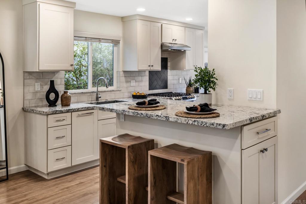 3163 Via De Caballo Encinitas, CA 92024 - Photo 3 of 23 a kitchen with granite countertop a sink stove and cabinets