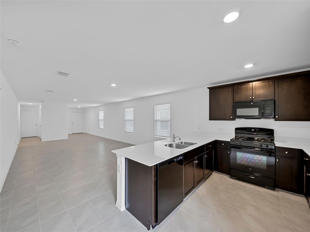 7765 Ruellia Road McKinney, TX 75071 - Photo 10 of 40 a kitchen with stainless steel appliances granite countertop a sink and a stove