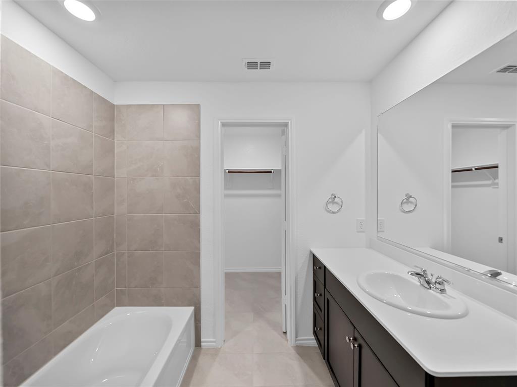 7765 Ruellia Road McKinney, TX 75071 - Photo 16 of 40 a bathroom with a tub sink shower and mirror