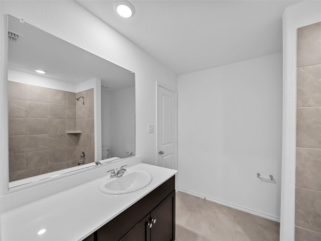 7765 Ruellia Road McKinney, TX 75071 - Photo 17 of 40 a bathroom with a sink and a mirror