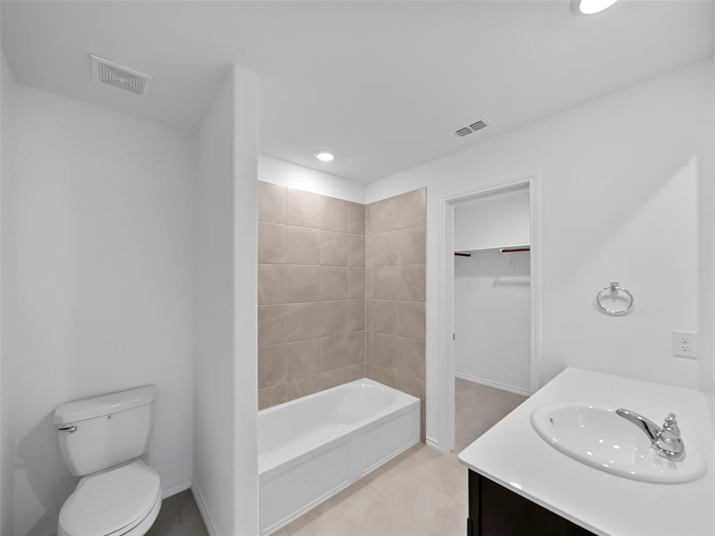 7765 Ruellia Road McKinney, TX 75071 - Photo 19 of 40 a bathroom with a sink a toilet and shower