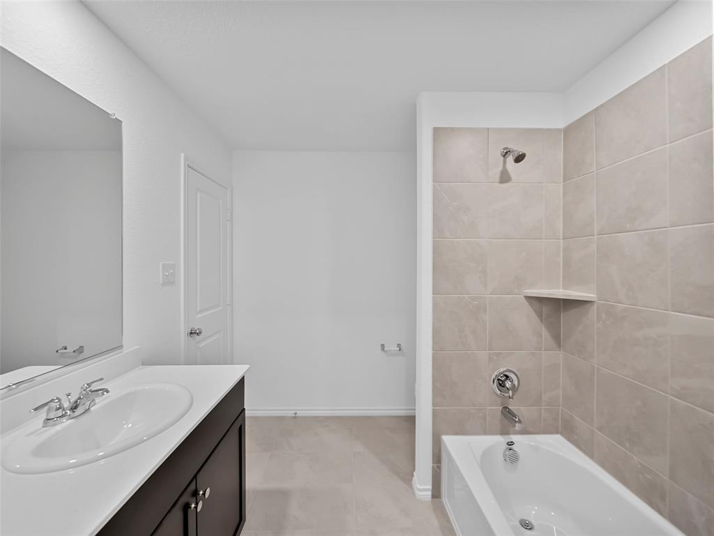 7765 Ruellia Road McKinney, TX 75071 - Photo 20 of 40 a bathroom with a bath tub sink mirror and a shower